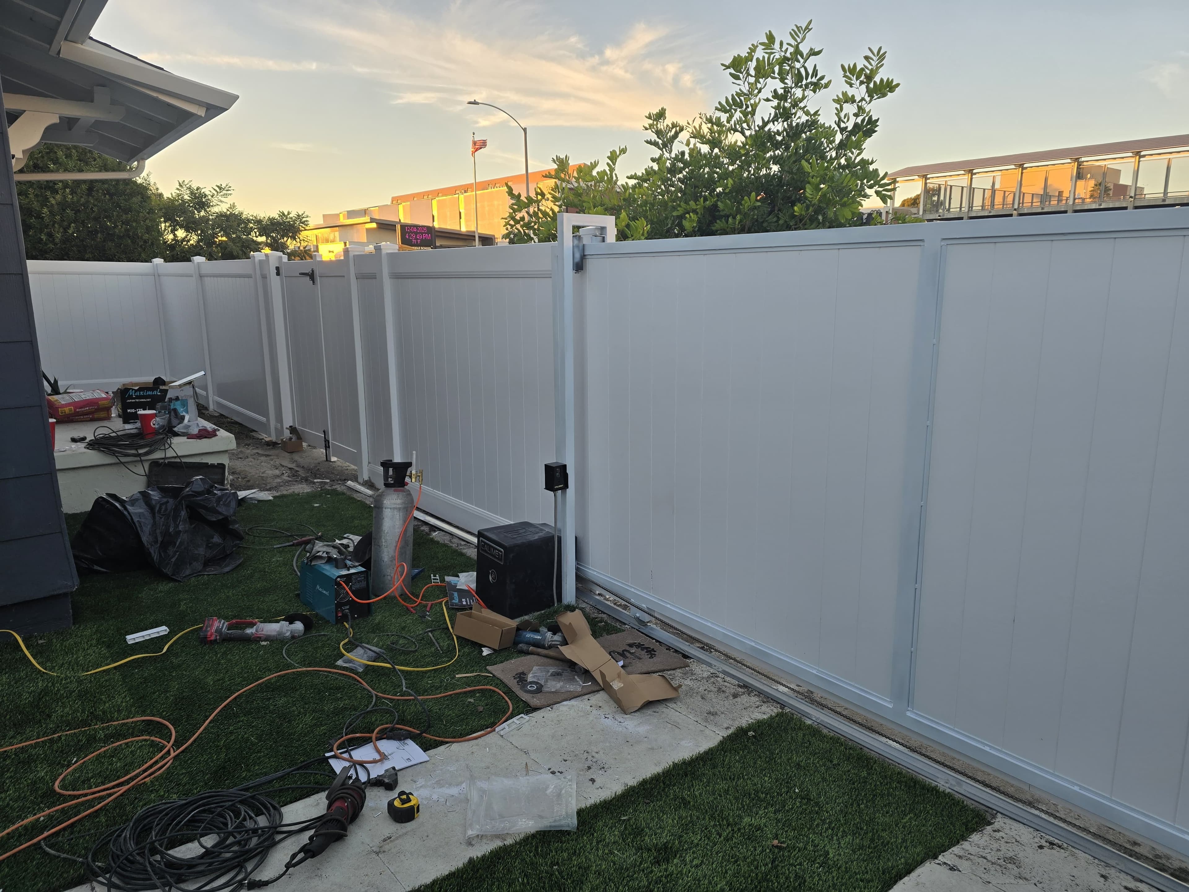 Long run of white vinyl privacy fence panels beside a residential property