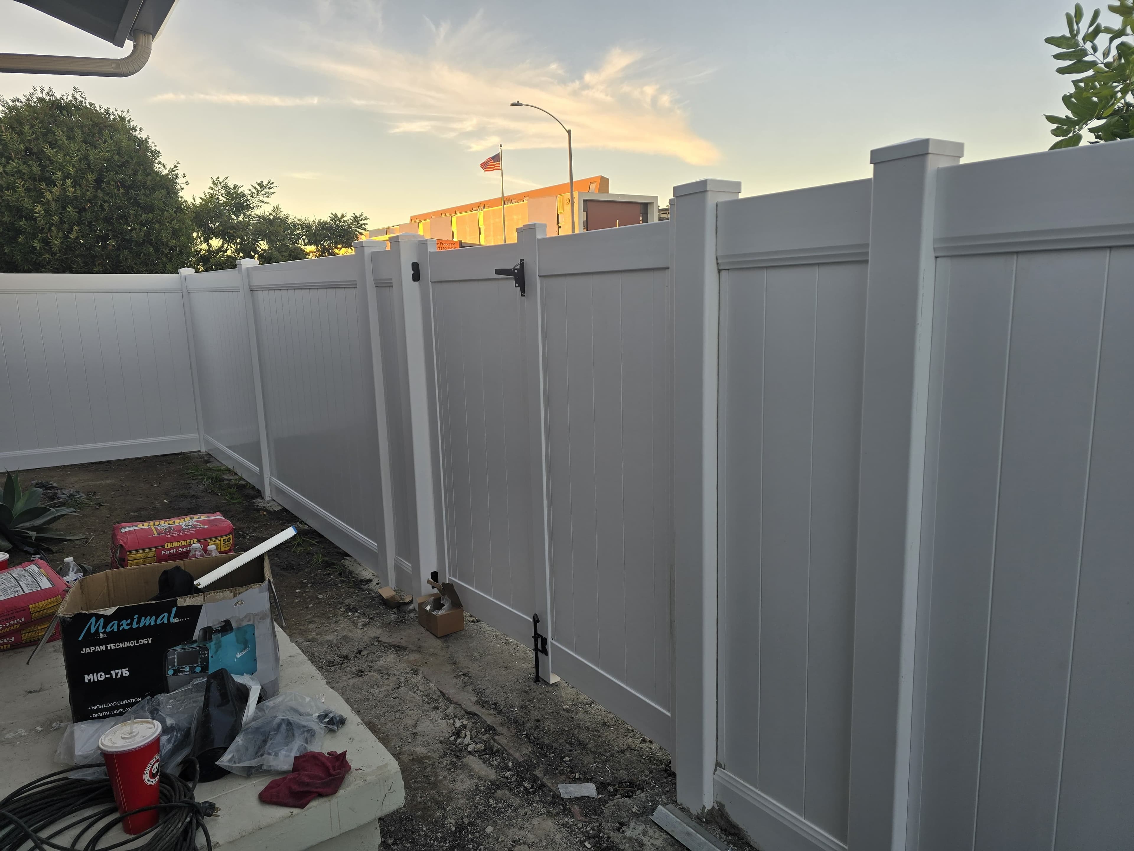 White vinyl privacy fence panels and gate in a side yard