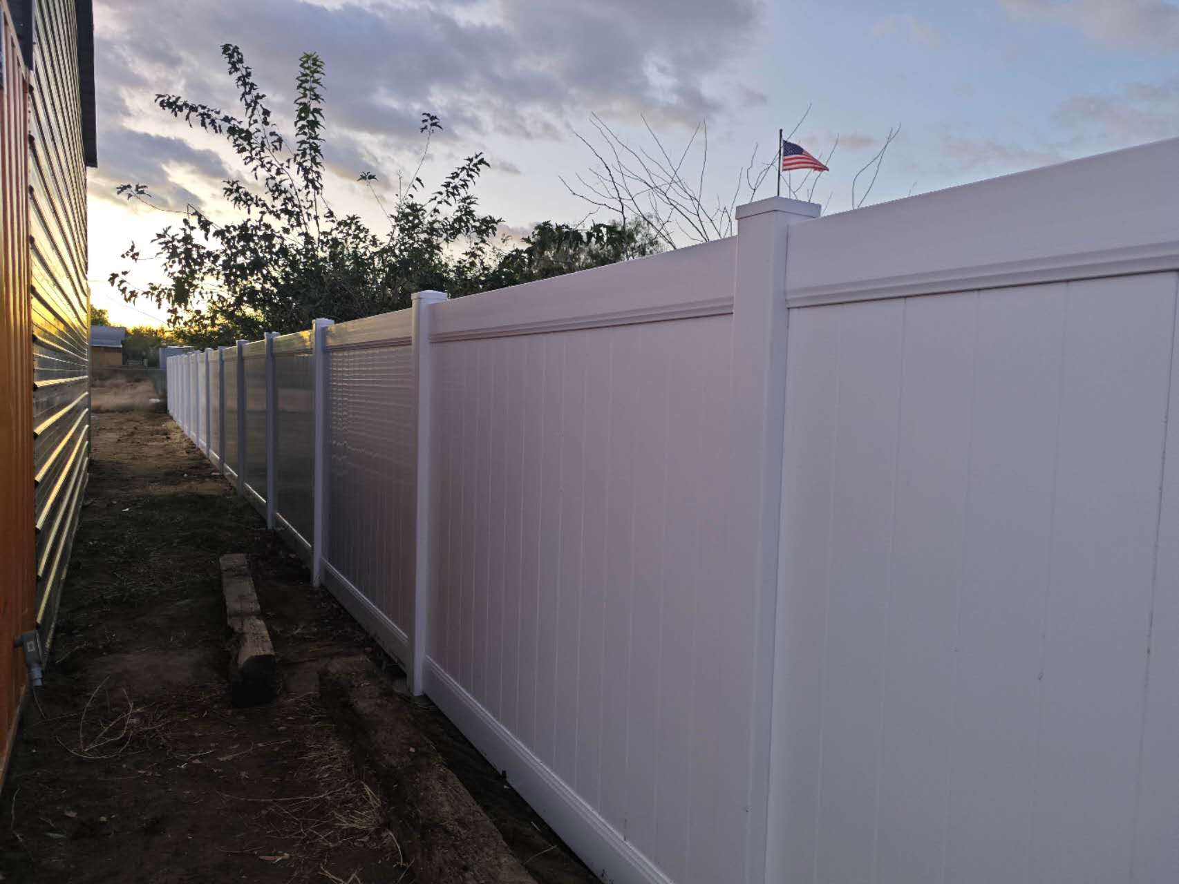 Overview of a completed white vinyl privacy fence