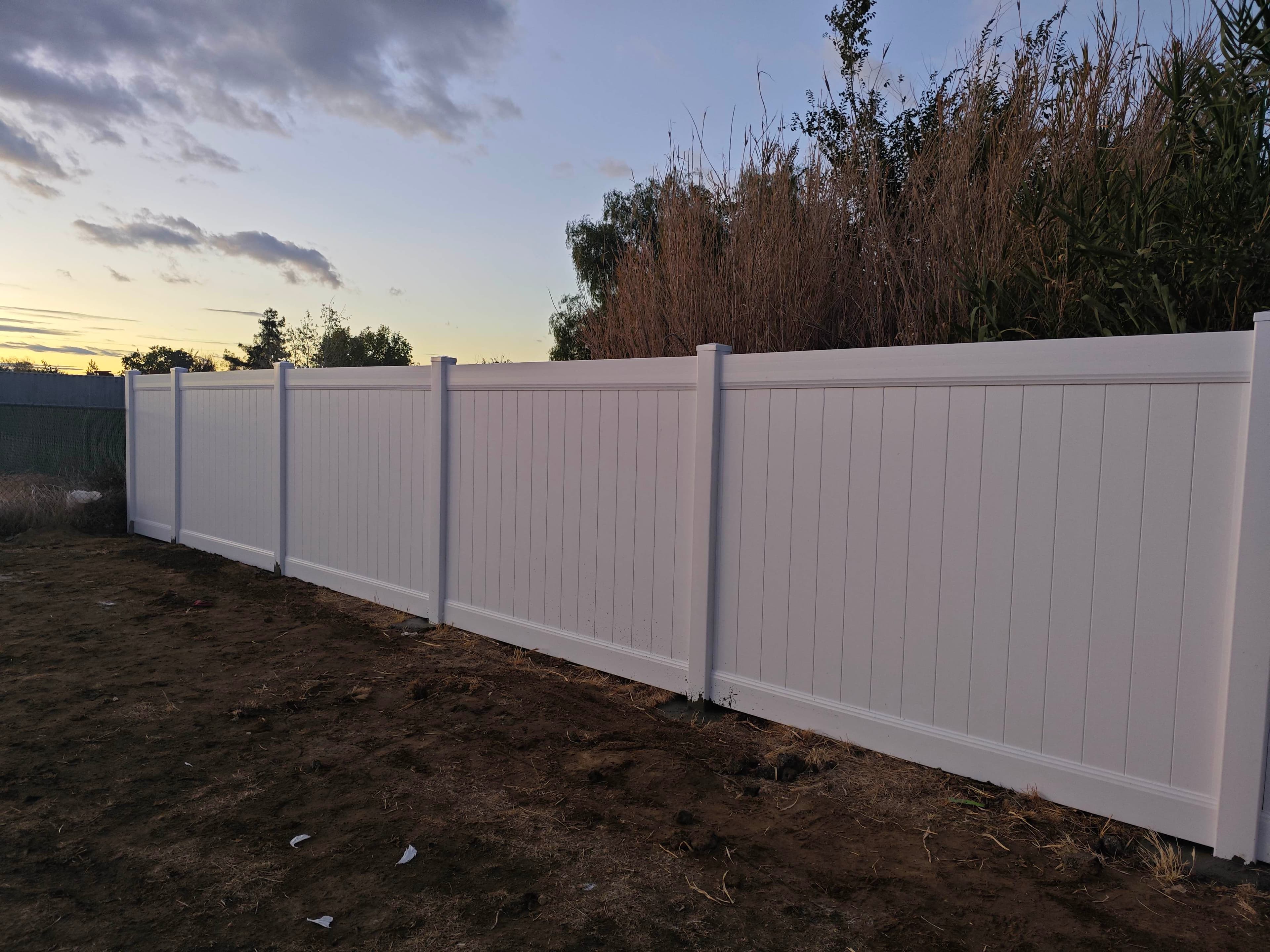 Close view of white vinyl fence panels and posts