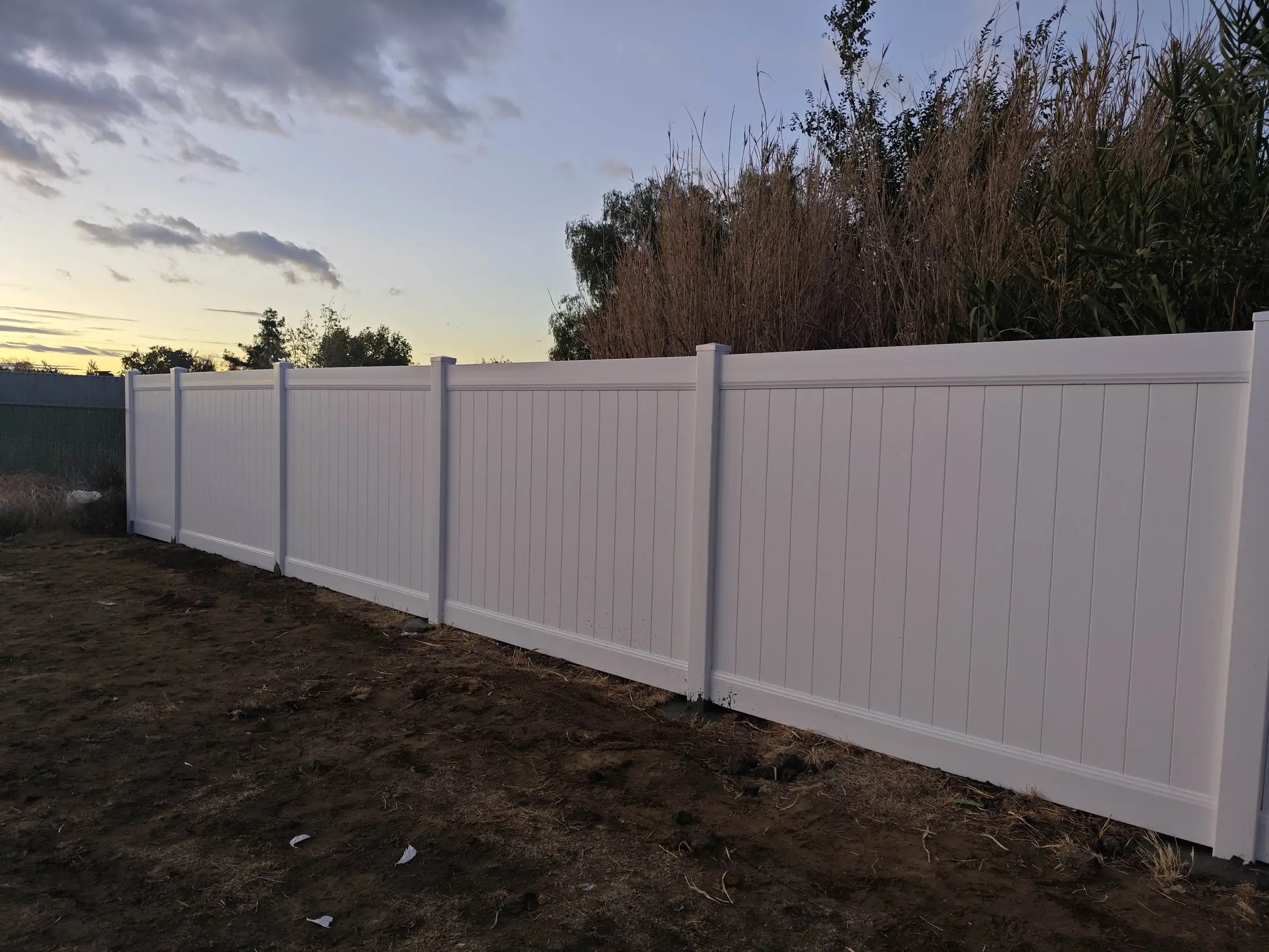 Close view of white vinyl fence panels and posts