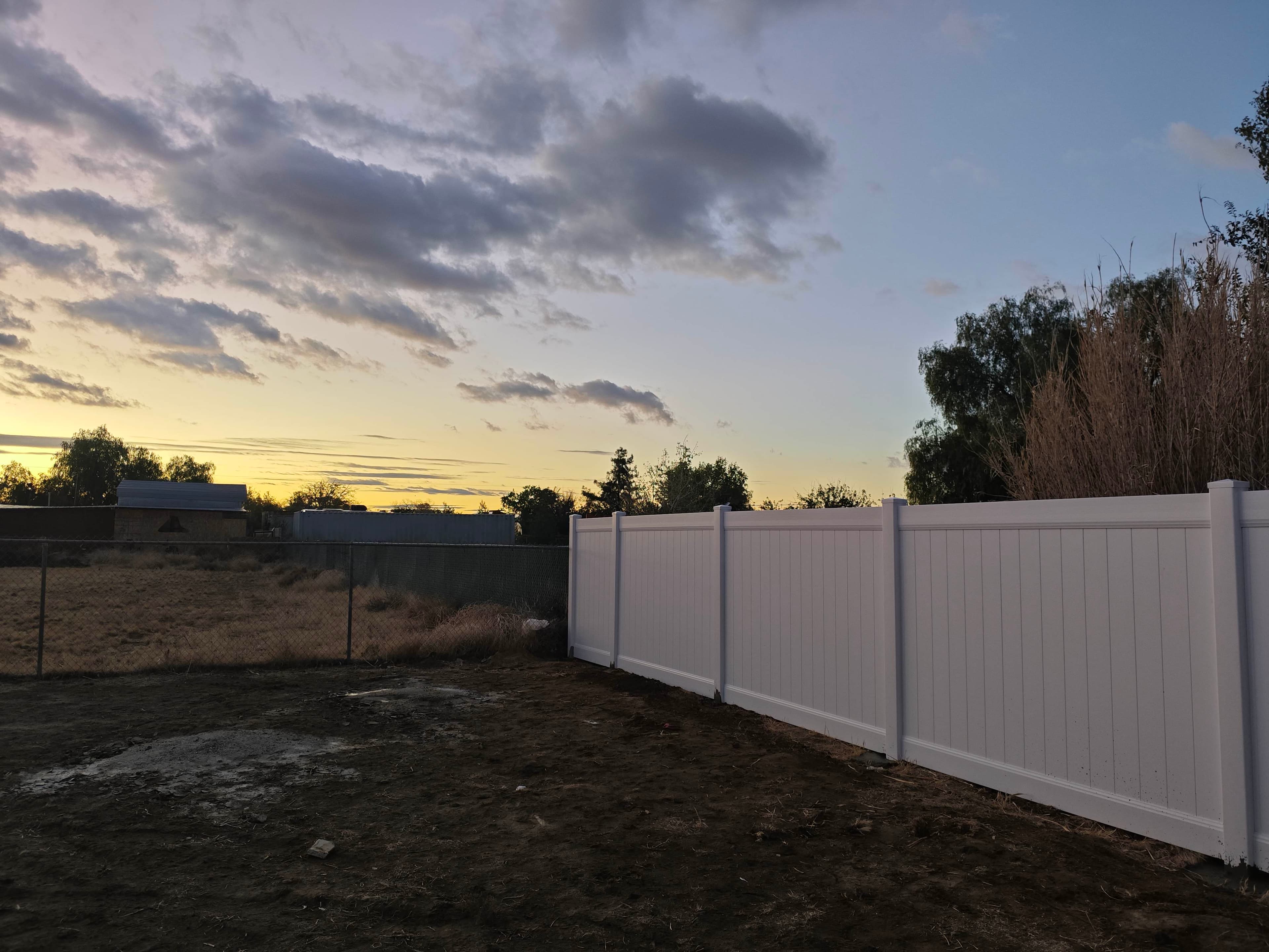 White vinyl fence panel run beside a residential property