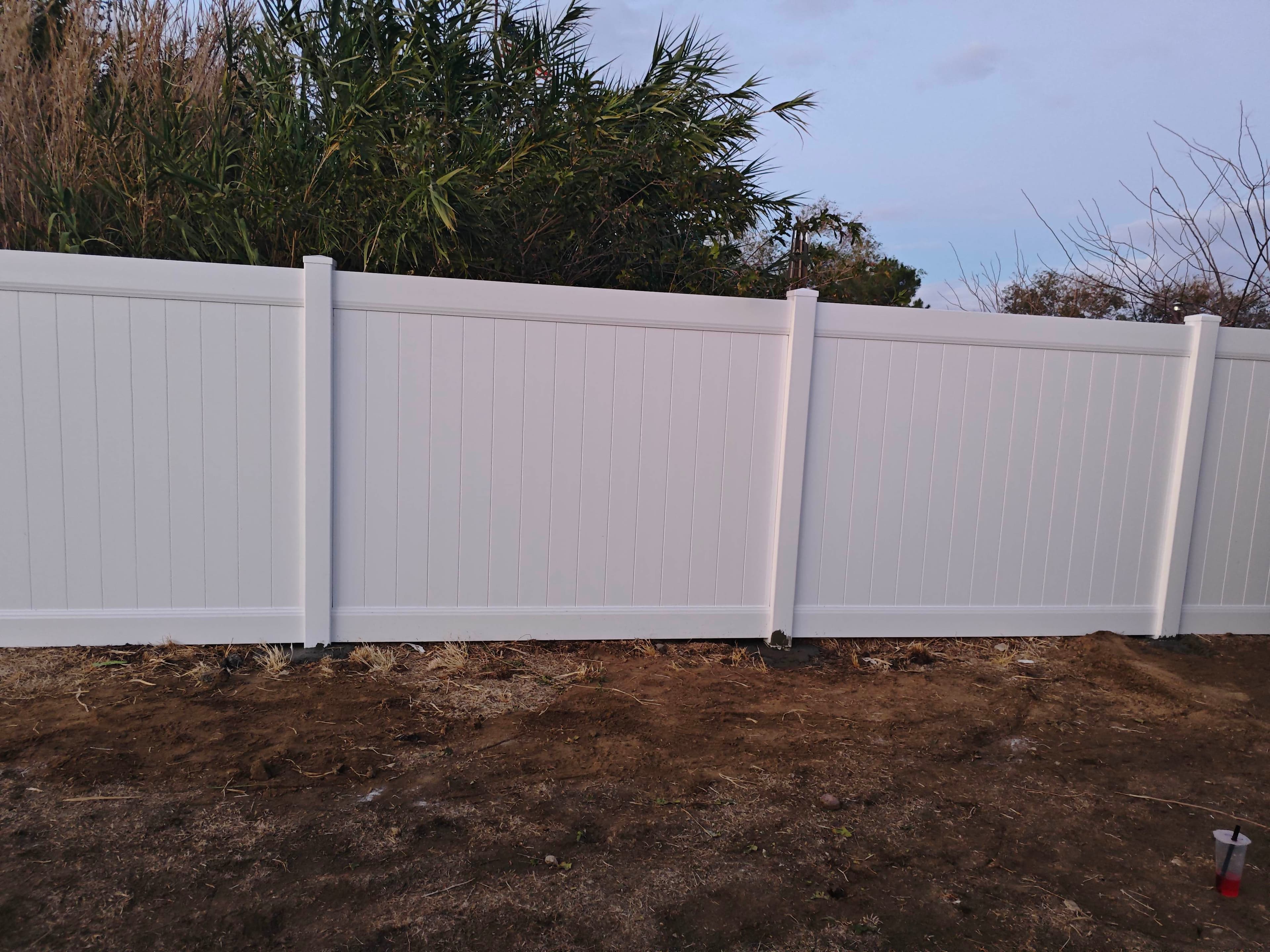 White vinyl privacy fence viewed from inside a yard